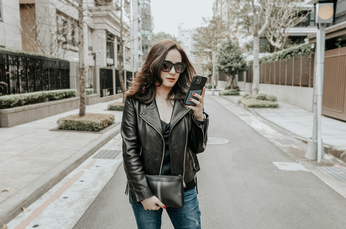 a woman standing on a street holding a cell phone