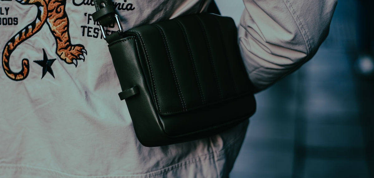 A man in a white shirt carrying a black bag