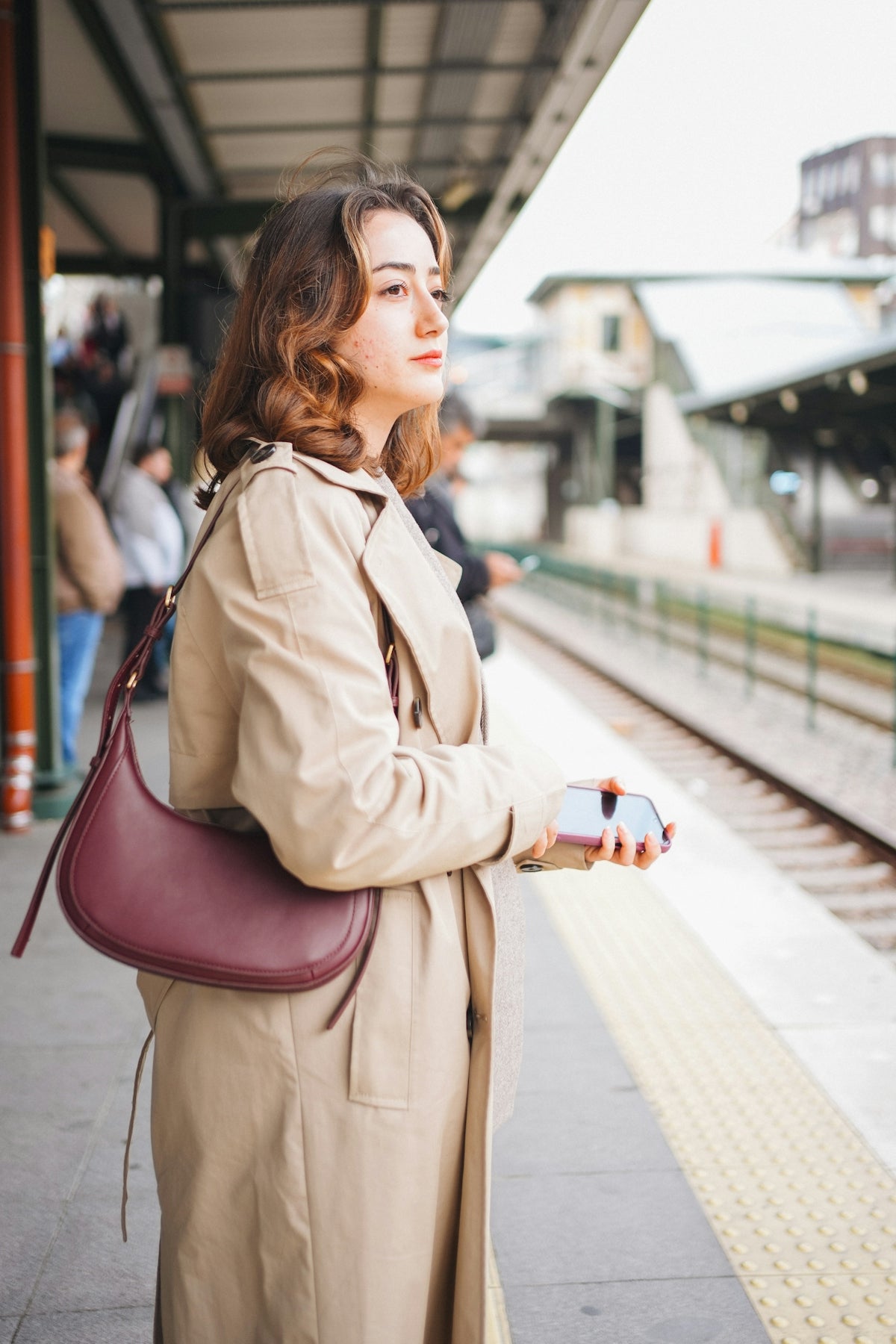 A woman waits for the train at the station.