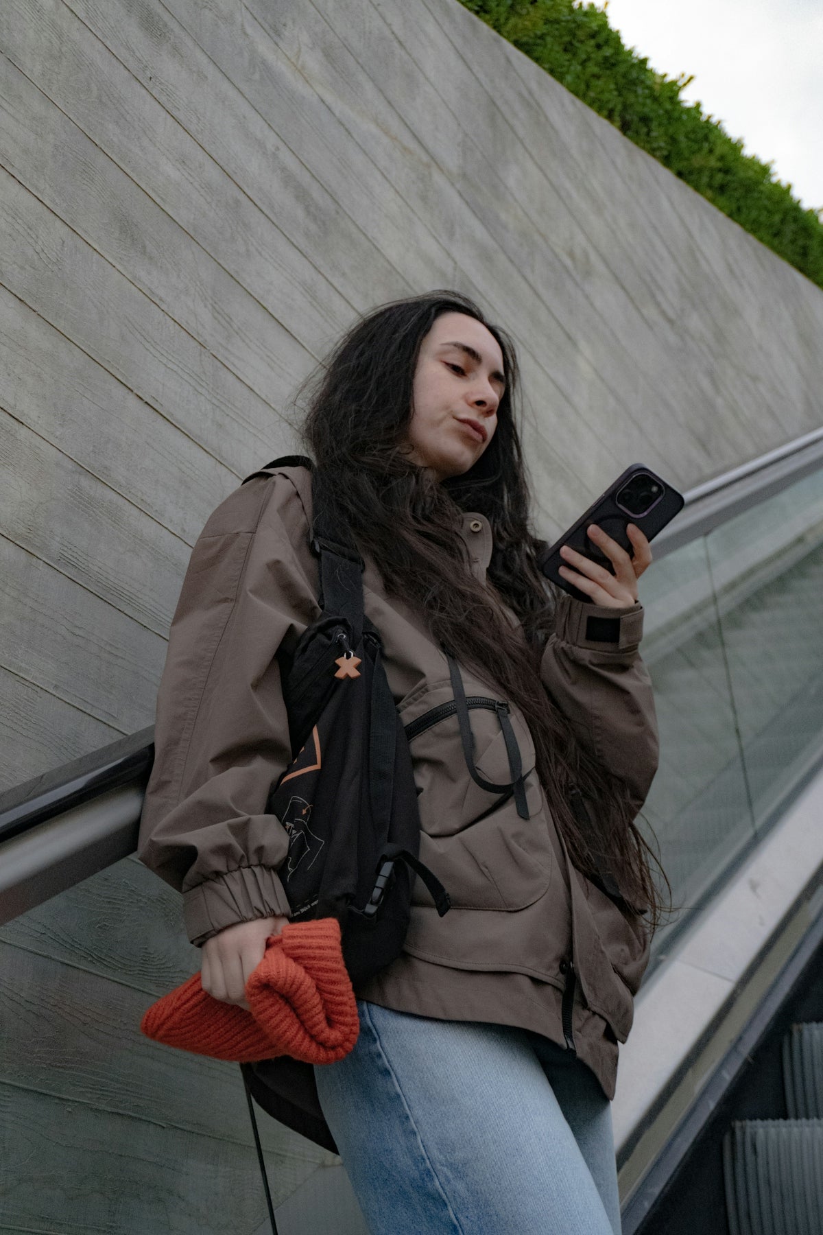 Una dona controlla il suo telefono su una rampa